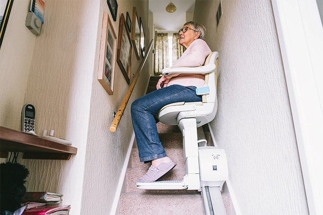 Person riding stairlift which is part of an accessible staircase design