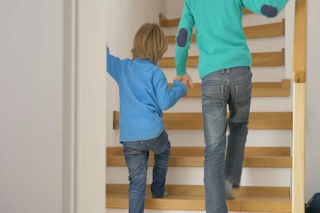 Parent and child going up stairs that are the right width