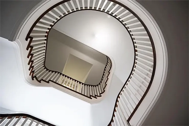 Looking up through a curved wooden staircase