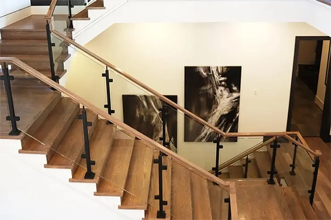 Wooden stairs with glass railing topped with wood handrail