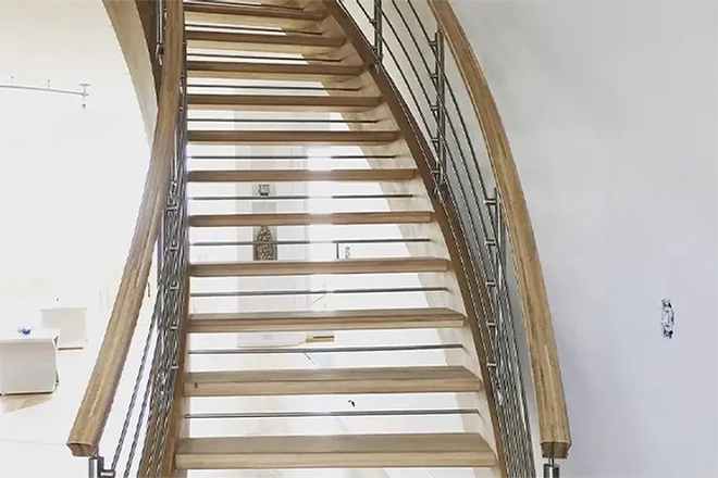 A light wood open riser staircase with metal horizontal spindles