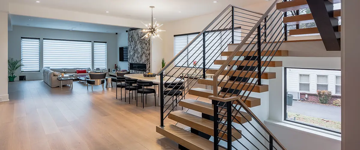 modern open staircase with horizontal metal railing and wood treads