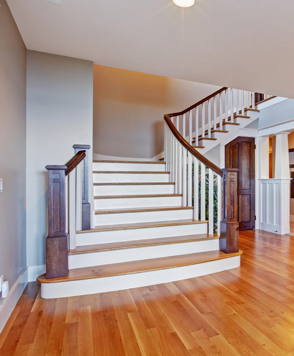 Straight staircase with wood treads, white risers, and dark wood posts flowing into a new hardwood floor installation in Alexandria, VA.