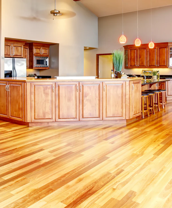 Spacious kitchen showcasing a new light-toned hardwood floor installation in Vienna, VA, complementing the wooden cabinets and island.