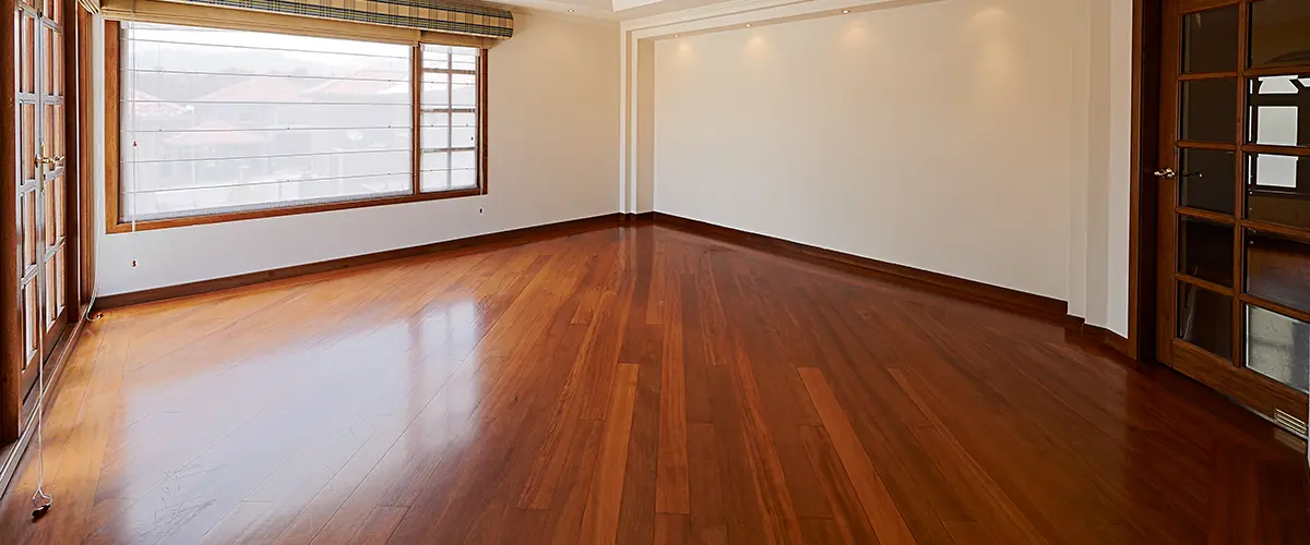 hardwood flooring in spacious room with wood trim and doors