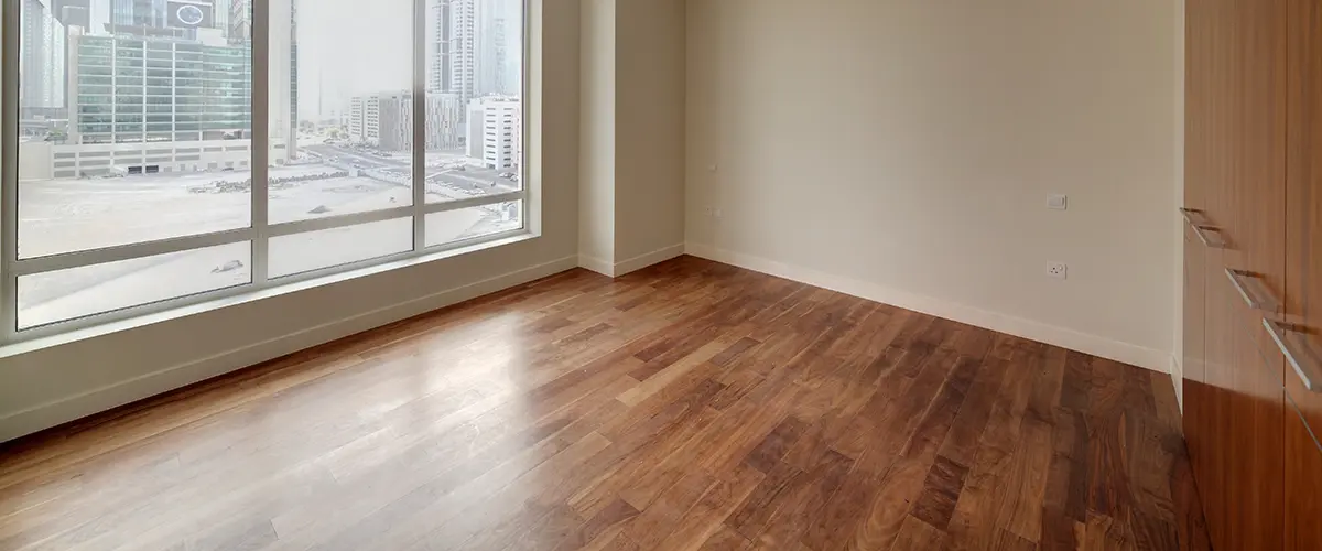 hardwood flooring in modern room with large window and city view