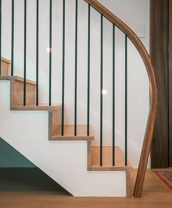 Stair Design in Vienna, VA 1 Curved wood staircase with black metal balusters in modern residential interior