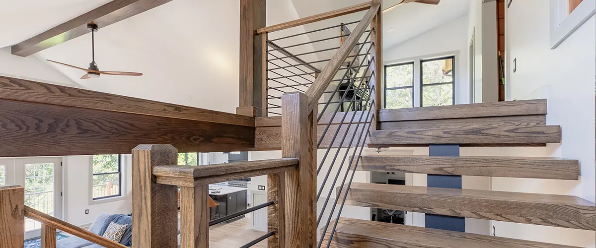 Floating wood staircase with cable railing in modern custom home interior design