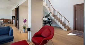 Modern luxury living room with curved wood staircase and contemporary hardwood flooring