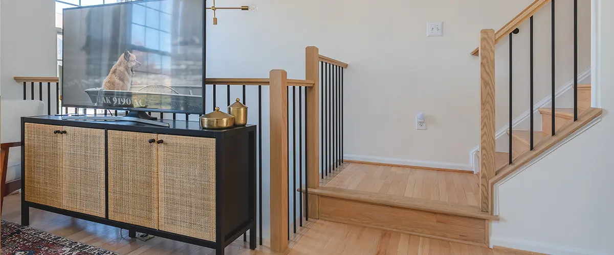 Oak staircase with black iron balusters and custom railing in bright residential living space